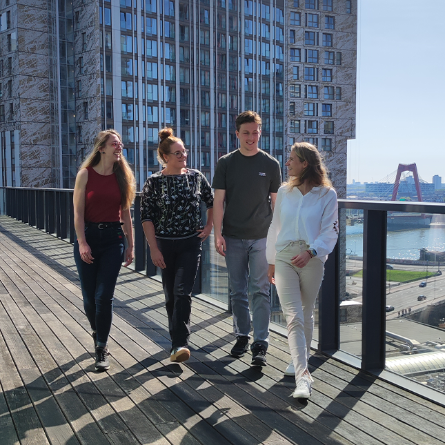 Team van Touch Incentive loopt samen over dakterras in Rotterdam met uitzicht op de stad